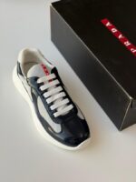 Prada Sneakers in white leather with bold red accent stripe and rubber logo patch