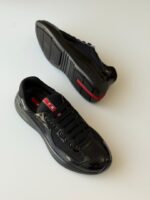 Prada Sneakers in white leather with bold red accent stripe and rubber logo patch