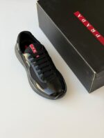 Prada Sneakers in white leather with bold red accent stripe and rubber logo patch