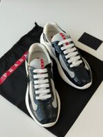 Prada Sneakers in white leather with bold red accent stripe and rubber logo patch