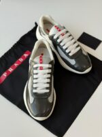 Prada Sneakers in white leather with bold red accent stripe and rubber logo patch