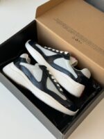 Prada Sneakers in white leather with bold red accent stripe and rubber logo patch